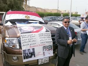 منسق حملة صباحي امام السفارة وبجواره بوستر لاسماء ابرز مؤيدي صباحي﻿