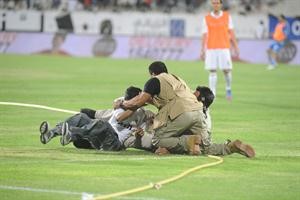 رجال الامن يمسكون بطفل اقتحم الملعب بين شوطي المباراة
