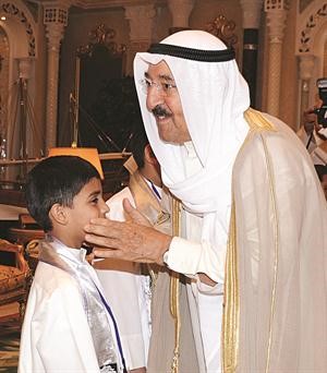 صاحب السمو الامير مصافحا احد الطلبة المتفوقين