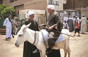 مصري على حمار يتحدث مع صديقه بعد التصويت في الجيزةاپ