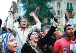 محتجون مصريون يلوحون باحذيتهم في ميدان التحرير خلال تظاهرة معارضة لمرشحي الرئاسة د محمد مرسي واحمد شفيق قبل جولة الاعادة رويترز