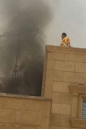 احد رجال الاطفاء يعاين موقع الحريق ويبدو الدخان الكثيف