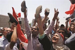 المتظاهرون في ميدان التحرير يرفعون الاحذية احتجاجا على اجتياز شفيق المرحلة الاولى من انتخابات الرئاسة المصريةرويترز﻿