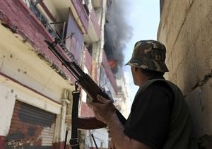 احد المسلحين ينظر الى الحريق المندلع جراء الاشتباكات في التبانة بطرابلس محمود الطويل