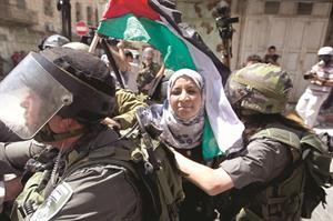 جنود الاحتلال الاسرائيلي يعتقلون احدى المتظاهرات الفلسطينيات في ذكرى النكسة بالخليل	افپ﻿