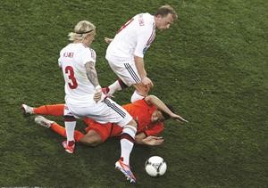 لاعب المنتخب الهولندي ابراهيم افيلاي على الارض وسط لاعبي الدنمارك سيمون كاير ومايكل كرون