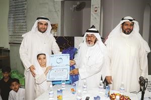 الزميل يوسف عبدالرحمن والزميل محمد راتب يكرمان احد الاطفال الموهوبين