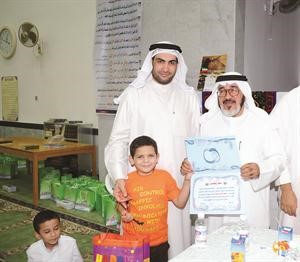 الزميل يوسف عبدالرحمن والزميل محمد راتب يكرمان احد الحفظة الصغار
