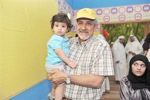 دهلال الساير يحمل احد الاطفال المصابين