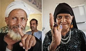 مسنان يرفعان اصبعيهما بعد غمسهما في الحبر الازرق بعد الادلاء بصوتيهما امس في الجيزة اپ
