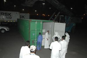 عدد من رجال المباحث والجمارك يعاينون الخمور بعد ضبطها في صبحان واعادتها الى ميناء الشويخ