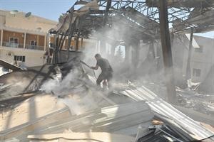 سوري يحاول اطفاء النيران في موقع الهجوم على قناة الاخبارية السورية افپ 