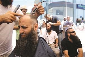 الشيخ احمد الاسير يحلق شعره في ساحة الاعتصام في صيدا