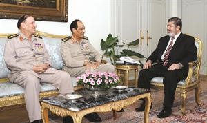 الرئيس دمحمد مرسي مستقبلا المشير محمد حسين طنطاوي ورئيس الاركان سامي عنان في القصر الجمهوري امس افپ 