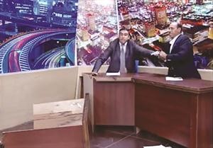 صورة تلفزيونية تظهر النائب الاردني محمد الشوابكة وهو يشهر مسدسه على المعارض منصور سيف الدين الذي فر من امامه