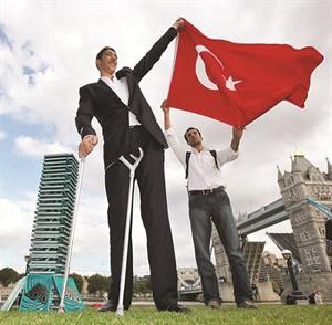 التركي سلطان كوزين اطول رجل في العالم رافعا علم بلاده﻿