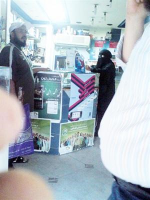  وصورة لمنتقبة داخل محل للمحمول