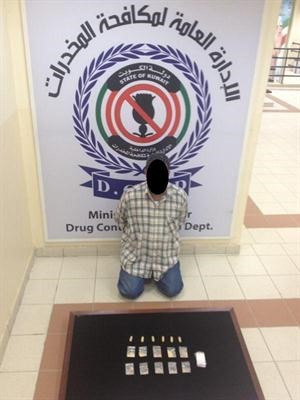 الاسيوي وامامه كمية المخدرات المضبوطة﻿
