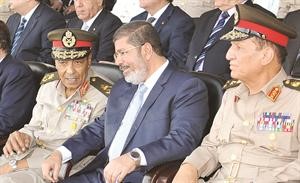 الرئيس المصري د محمد مرسي متوسطا المشير طنطاوي ورئيس الاركان عنان في حفل تخرج بالكلية الحربية اپ