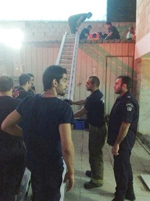 رجال الاطفاء والطوارئ الطبية خلال محاولاتهم انزال المصابة المصرية من اعلى غرفة الحارس﻿