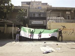 مسلحو الجيش الحر يرفعون علما كبيرا للثورة بعد سيطرتهم على قسم شرطة الانصاري في حلب اپ
