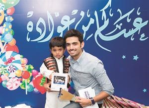مسؤول العلاقات العامة في بنك الكويت الوطني مع احد الاطفال المشاركين﻿
