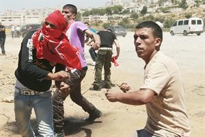 فلسطينيون يرمون قوات الاحتلال بالحجارة خلال مظاهرة لدعم المعتقلين في سجن عوفر العسكري 	اپ﻿