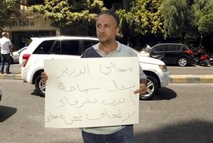 احد المؤيدين للوزير السابق ميشال سماحة يرفع لافتة تستنكر الاعتقال	محمود الطويل﻿