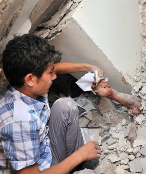 طفل يمسك بيد احد ذويه تحتانقاض منزليه في اعزاز اافپ