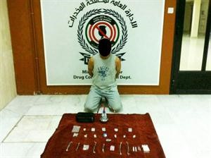 المواطن المتهم بالاتجار بالهروين وامامه الكمية المضبوطة ﻿