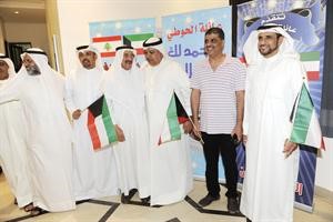 الحوطي محاطا بمهنئيه واعلام الكويت﻿