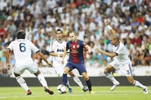 لاعب وسط برشلونة اندريس انييستا محاصرا بين الثلاثي بيبي وانخيل دي ماريا وسامي خضيرة
