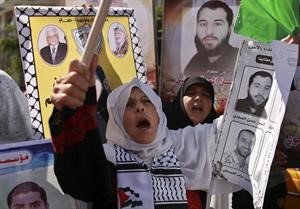 سيدتان فلسطينيتان ترفعان صور اقربائهما المعتقلان لدى الاحتلال الاسرائيلي 	روريترز﻿