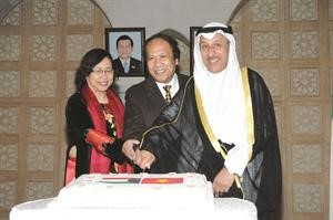 السفير خالد المغامس مشاركا السفير الفيتنامي بوي كووك ترونغ والسيدة حرمه قطع كيكة الاحتفال﻿