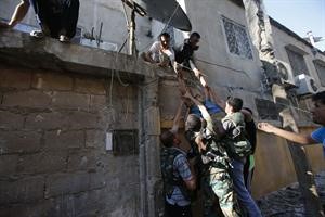 عناصر من الجيش الحر ينقلون جثة احد زملائهم قتل برصاص قناص في حلب 	افپ﻿