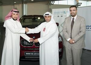 من الوسط الى اليسار حسين الصراف يسلم المفاتيح الى نواف يوسف احمد الخشان الفائز بسيارة BMW
