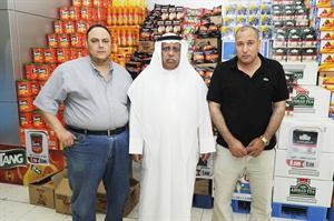 فهاد النويعم والمدير التجاري سنجام محمد علي ومدير السوق كمال حنا امام بعض المنتجات المشمولة بالخصومات﻿