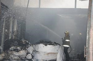 احد رجال الاطفاء يكافح حريق ورشة تغليف المحارم﻿