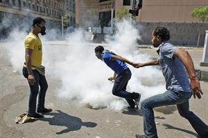 متظاهرون مصريون يفرون من الغاز خلال اشتباكهم مع الشرطة بالقرب من السفارة الامريكية في القاهرة امس اپ
