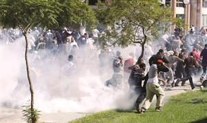 محتجون يحاولون تجنبالغاز المسيل للدموع لمنعهم من اقتحام السفارة الاميركية في تونس رويترز