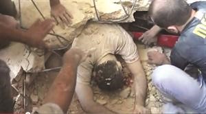 سوريون يحاولون انتشال جثة احد القتلى من تحت انقاض منزله الذي تهدم نتيجة القصف في حي الميسر بحلب﻿