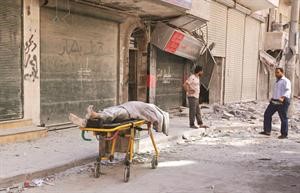 مدنيون يحاولون نقل جثة مدني في الشارع بعد غارة جوية على حي الشعار بحلب امس	رويترز﻿