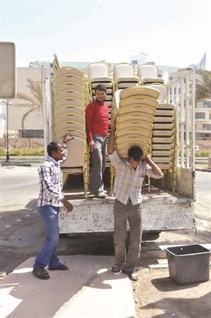 عمال يحملون الكراسي الى ساحة الارادة