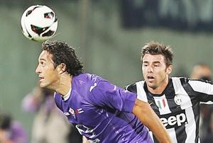 مهاجم فيورنتينا لوكاطوني يمر بالكرة من لاعب يوفنتوس اندريا بارزاغلي اپ
