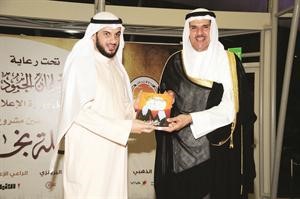 الشيخ سلمان الحمود متسلما كتاب رحلة نجاح من الزميل ناصر الخالدي