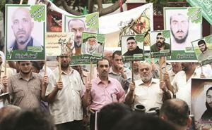 فلسطينيون من غزة يحملون صور اقربائهم المعتقلين في مظاهرة احتجاجا على منع زيارتهمافپ﻿