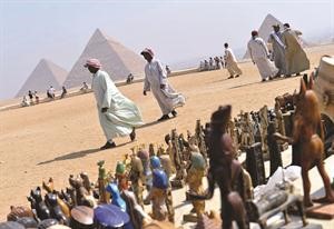 مصريون يبيعون تذكارات للسائحين امام الاهرامات افپ