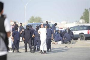 افراد من القوات الخاصة خلال اعتقالهم شخصين احدهما مطروح ارضا والاخر مكبل من اليدين ويبدو من الخلف اثار القنابل الدخانية﻿