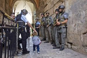 الشرطة الاسرائيلية تراقب طفلا فلسطينيا يدخل الى باحة المسجد الاقصى وبيده عصا 	رويترز﻿