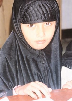 فتاة مسلمة في عينيها نظرة امل وتصميم نحو المستقبل
